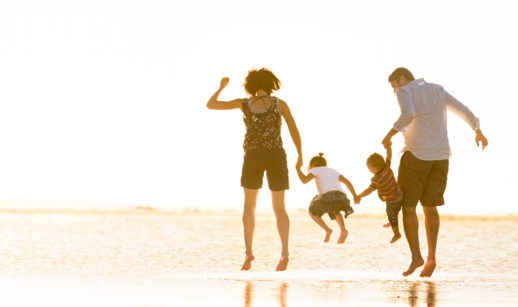 família se divertindo na praia, alusivo a segurança oferecida e a possibilidade de planejar o futuro com os produtos de seguro