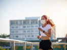 Mulher asiática correndo na rua com máscara de proteção