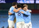 Jogadores do Manchester City se abraçando e comemorando gol