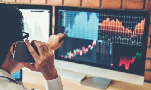 Mãos apontando para tela de computador com home broker