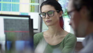 Mulher observando tela de broker com opções para se investir