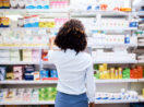 Mulher diante de prateleira de medicamentos