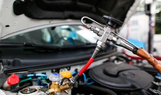 Capô de carro aberto sendo abastecido com gás natural veicular