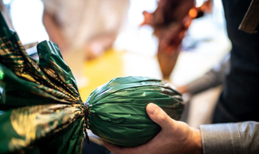 Ovo de Páscoa com embalagem verde na mão de uma pessoa