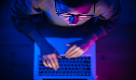 Pessoa em frente a notebook vista de cima e se precavendo de crimes virtuais