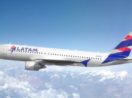 Avião da Latam Brasil em pleno voo com céu azul e poucas nuvens