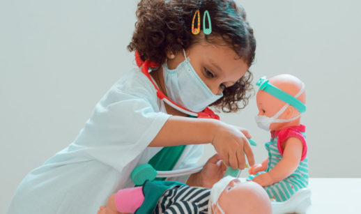 Criança brinca com bonecas de máscaras