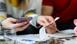 mãos calculando com calculadora e papéis