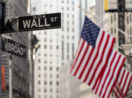 Bandeiras dos Estados Unidos com placa de Wall Street, alusivo aos BDRs para investir em agosto
