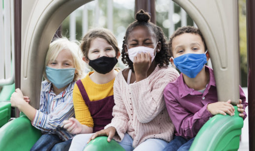 Quatro cirnaças com máscaras na escola