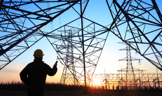 Silhuetas de torres de energia e trabalhador embaixo, alusivo à Energisa, que emitirá debêntures