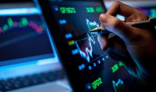 Mão de analista apontando para tela de broker, alusivo à marcação a mercado