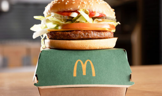 Hambúrguer vegetal McPlant, do McDonald's, sobre caixa na cor verde e logo da rede