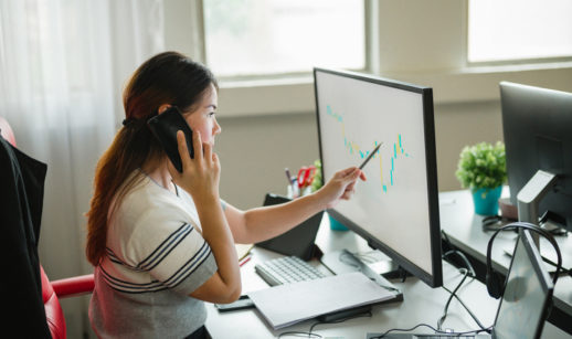 Mulher no computador observa gráficos