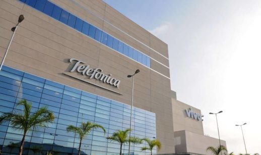 Fachada de prédios com letreiros da Telefônica e da Vivo lado a lado
