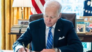 Joe Biden, presidente dos EUA que deve concorrer à reeleição, assinando papel