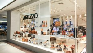 Fachada de loja da Arezzo, com vitrine cheia de sapatos, alusivo às novas ações