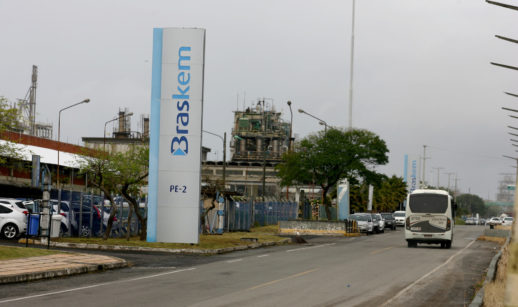 Entrada de unidade da Braskem, com destaque para totem e ônibus passando ao lado