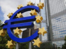 Entrada do banco central europeu, com destaque para logo do Euro, em azul, com estrelas em volta, alusivo aos índices Euro Stoxx 50 e DAX