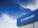 Fachada de fábrica da Embraer com destaque para o letreiro