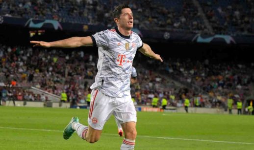 Robert Lewandowski, o melhor jogador de futebol do mundo, com uniforme do Bayern de Munique, comemorando gol durante jogo com os braços abertos