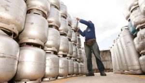 Funcionário empilhando botijão de gás, alusivo ao vale da Ultragaz