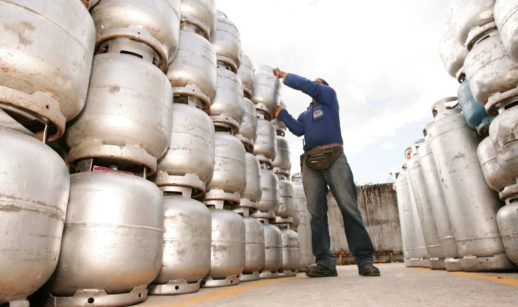 Funcionário empilhando botijão de gás, alusivo ao vale da Ultragaz