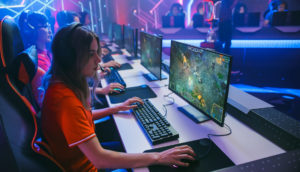 Atletas de eSports durante competição, enfileirados lado a lado, jogando games