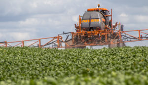 Veículo vermelho utilizado para espalhar fertilizante em terras produtivas no Brasil
