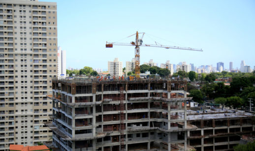 Prédio em construção, com guindaste ao fundo, alusivo às atividades da Plano&Plano