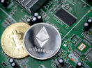 Conceito de duas criptomoedas de Bitcoin e Ethereum sobre chips de computador, alusivo à energia empregada na mineração