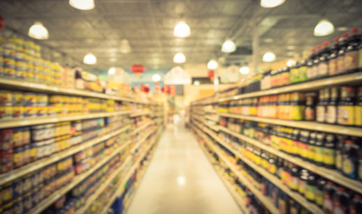 Imagem de corredor de supermercado com gôndolas desfocadas, alusivo à inflação do Brasil em 2022