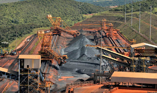 Mina de exploração de minério de ferro da Vale (VALE3), com maquinário pesado na cor laranja em destaque