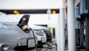 Frente de carros estacionados e carregando em postos de recarga de baterias nos EUA