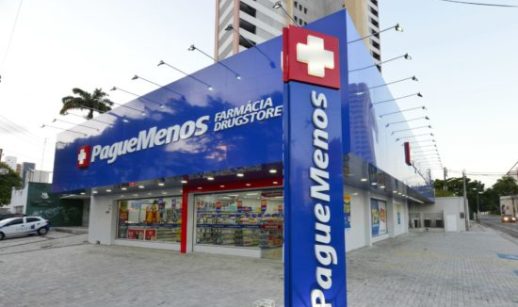 Fachada de loja da Pague Menos (PGMN3), com destaque para fundos azuis escuros com logo branco da empresa e cruz vermelha