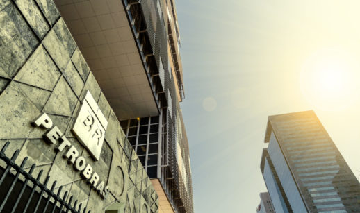 À esquerda, fachada da sede da Petrobras, cujas ações pagam bons dividendos, com destaque para o logo prateado e perspectiva de baixo para cima