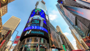 Perspectiva de baixo para cima de prédio da Nasdaq, onde gigantes de tecnologia têm ações em seu índice