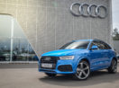 Audi Q3 na cor azul em frente à concessionária da empresa