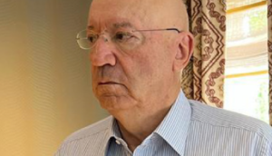 Carlos Pires de Oliveira, de lado, com óculos e camisa azul clara