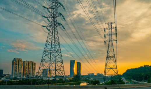 Torres de energia elétrica próximas ao Rio Pinheiros, em São Paulo, com pôr do sol ao fundo, alusivo à privatização da Eletrobras