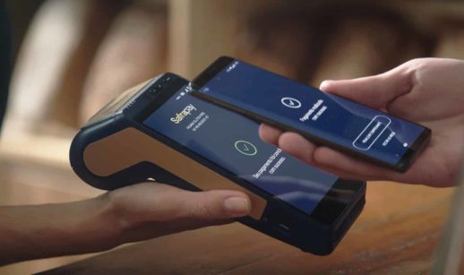Detalhe de máquina do SafraPay com celular se aproximando para pagar com o crédito