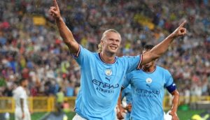 Erling Haaland, de braços abertos e uniforme do Manchester City, que lidera entre os times mais valiosos do mundo em elenco, comemorando um gol