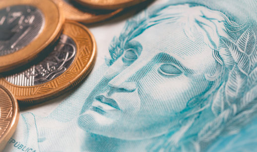 Detalhe de nota de real e moeda, alusivo à dívida pública federal