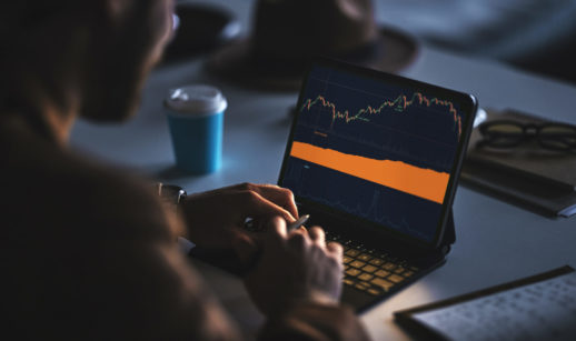 pessoa analisando gráfico de ações em um laptop, alusivo aos investimentos a longo prazo