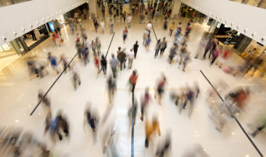 Interior de shopping movimentado, alusivo ao setor varejista