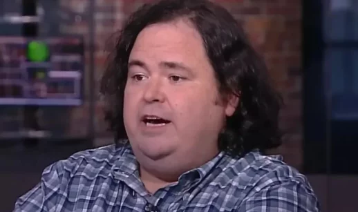 Blake Lemoine, com camisa xadrez azul e cabelo grande encaracolado solto