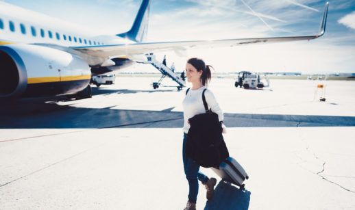 Passageira caminha para avião, alusivo às férias com cobertura do seguro viagem