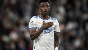Vinícius Júnior, de uniforme do Real Madrid, batendo no peito