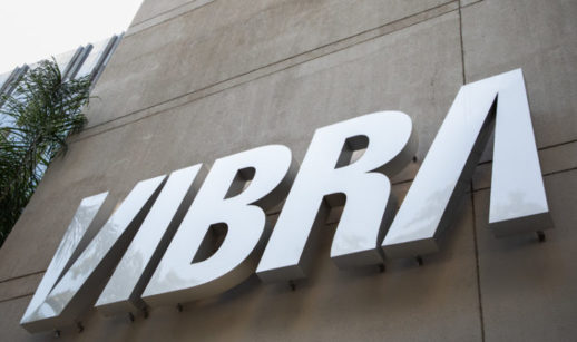 Perspectiva de baixo para cima de pilastra com logo da Vibra Energia em prata