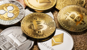 Conceito de criptomoedas nas cores prata e dourado sobre mesa, alusivo ao uso no Brasil